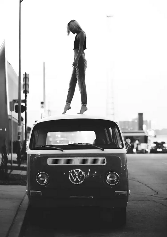 Camper van canvas painting with a person on the roof, in black and white on a city street