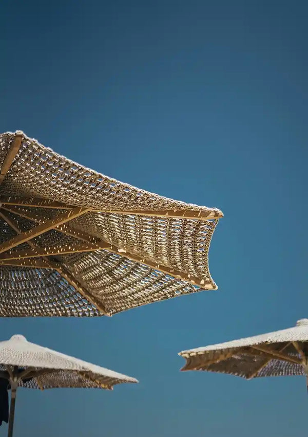 Geflochtene Strohschirme vor blauem Himmel Gemälde
