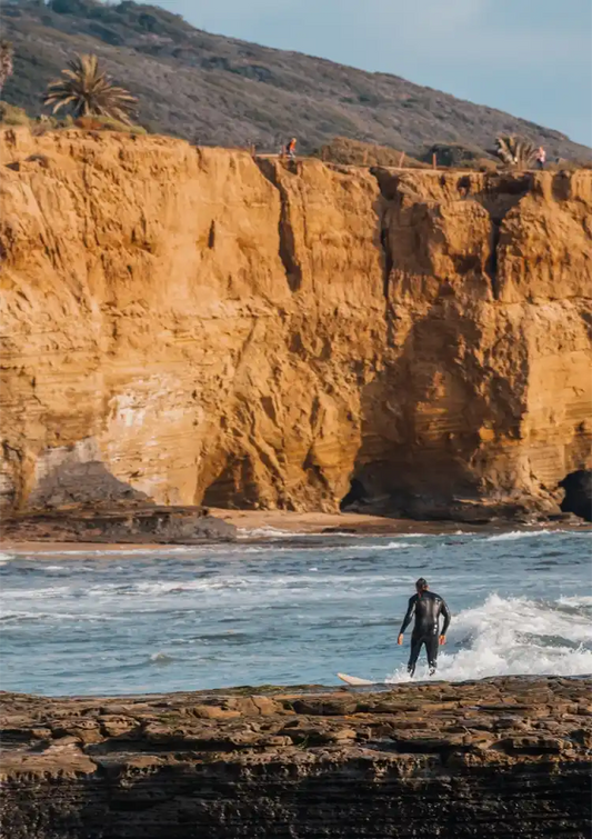 Surfer bij Gouden Kliffen Oceaan Golven Kustlandschap Canvas Schilderij