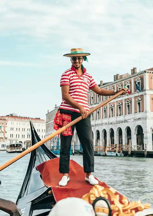 Gondolier w Wenecji obraz na płótnie w kolorach niebieskim, żółtym i brązowym.