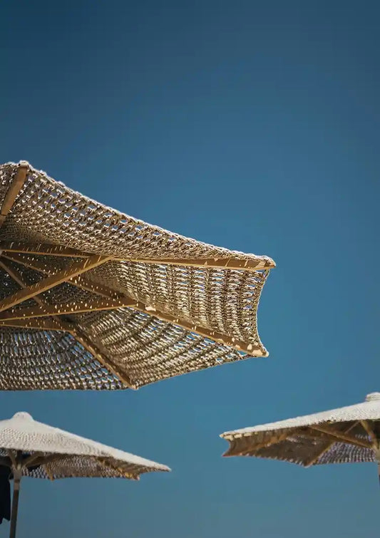 Geflochtene Strohschirme vor blauem Himmel Gemälde