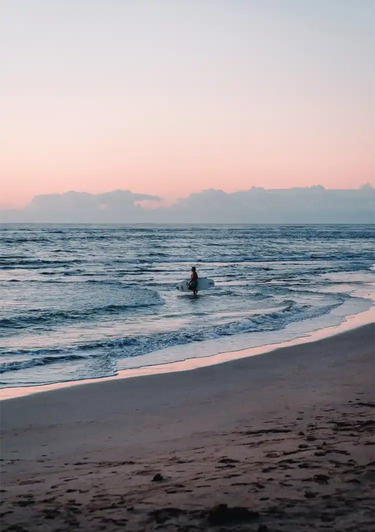 Surfer In Zee Bij Zonsondergang Pastelkleurige Lucht Schilderij