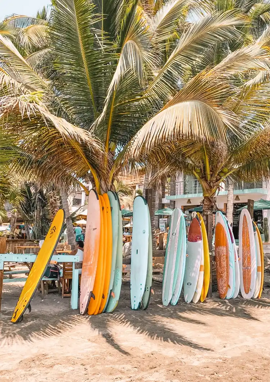 Kleurrijke surfplanken canvas schilderij in geel, blauw en oranje, tegen een palmboom