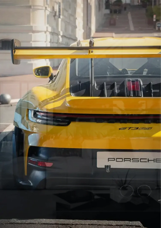 Yellow sports car from behind canvas painting on the wall in the hallway