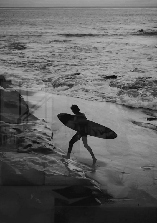 Surfer in zwart wit canvas schilderij aan de muur naast het bed in de slaapkamer