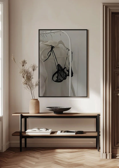 Schwarzer Spitzen-BH auf Kleiderständer, weißer Hintergrund, minimalistisches Schwarz-Weiß-Gemälde