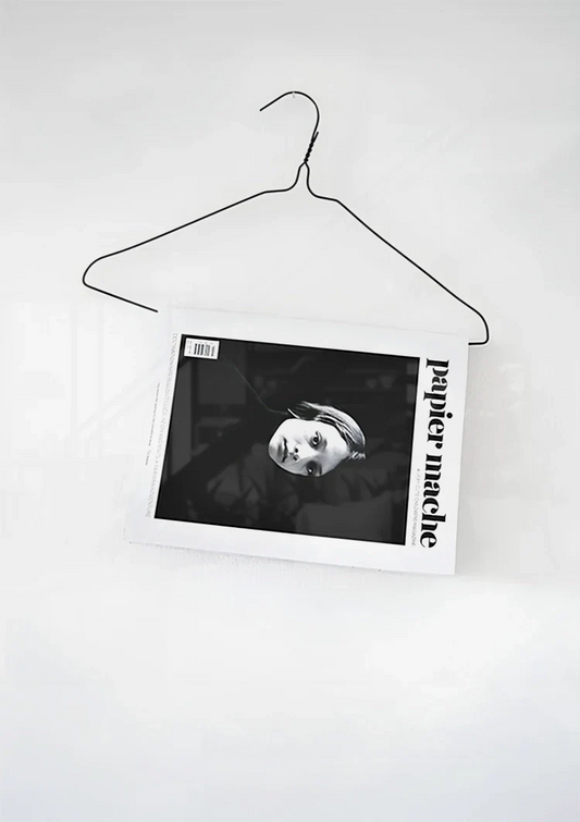 Kledinghanger met tijdschrift canvas schilderij aan de muur boven het bed in de slaapkamer