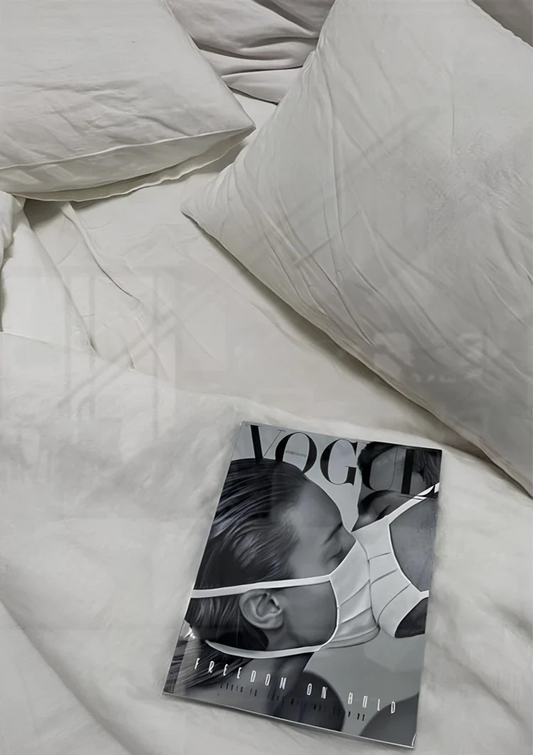 Tijdschrift op wit beddengoed canvas schilderij aan de muur boven het bed in de slaapkamer